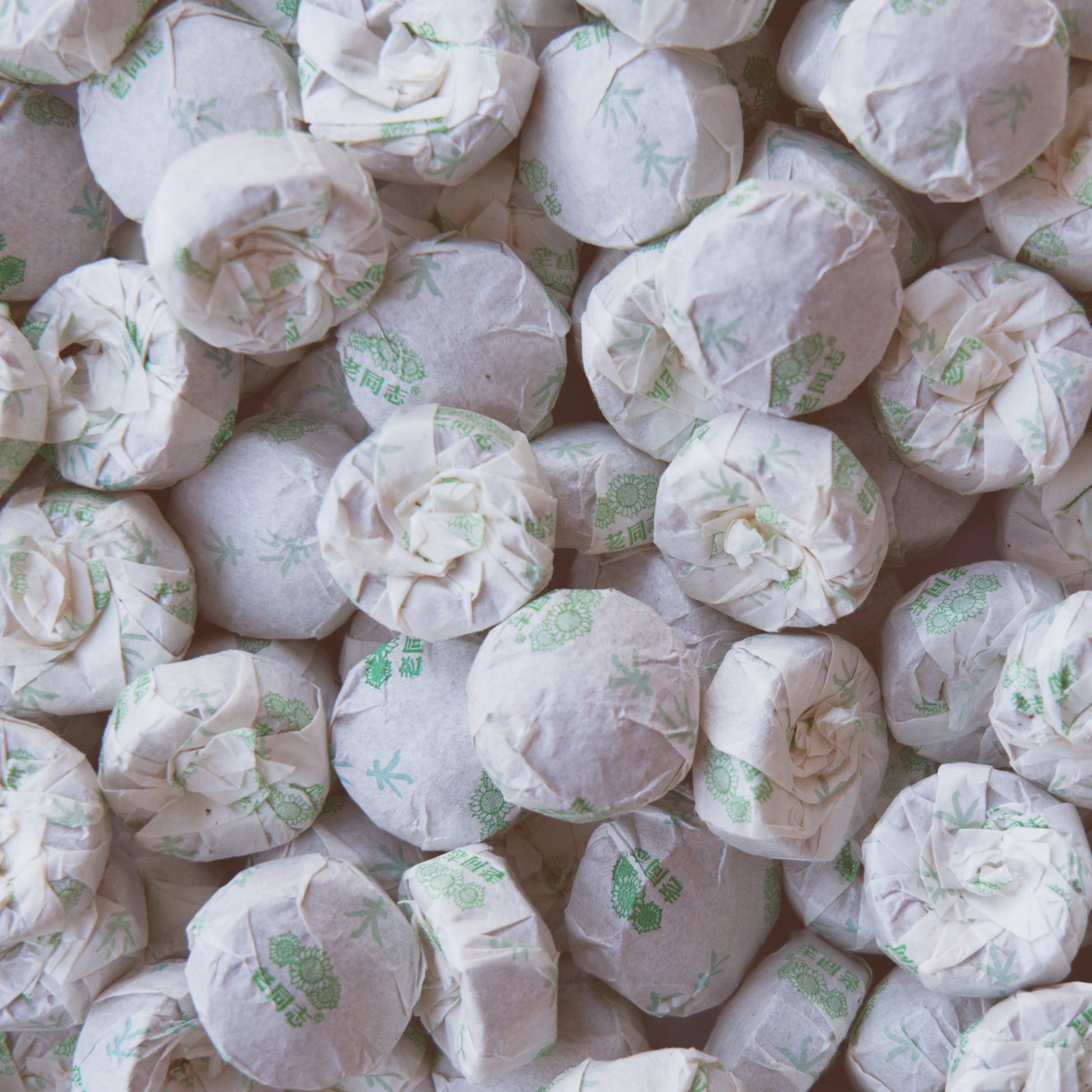 Close up of wrapped Haiwan raw puerh tea mini cakes