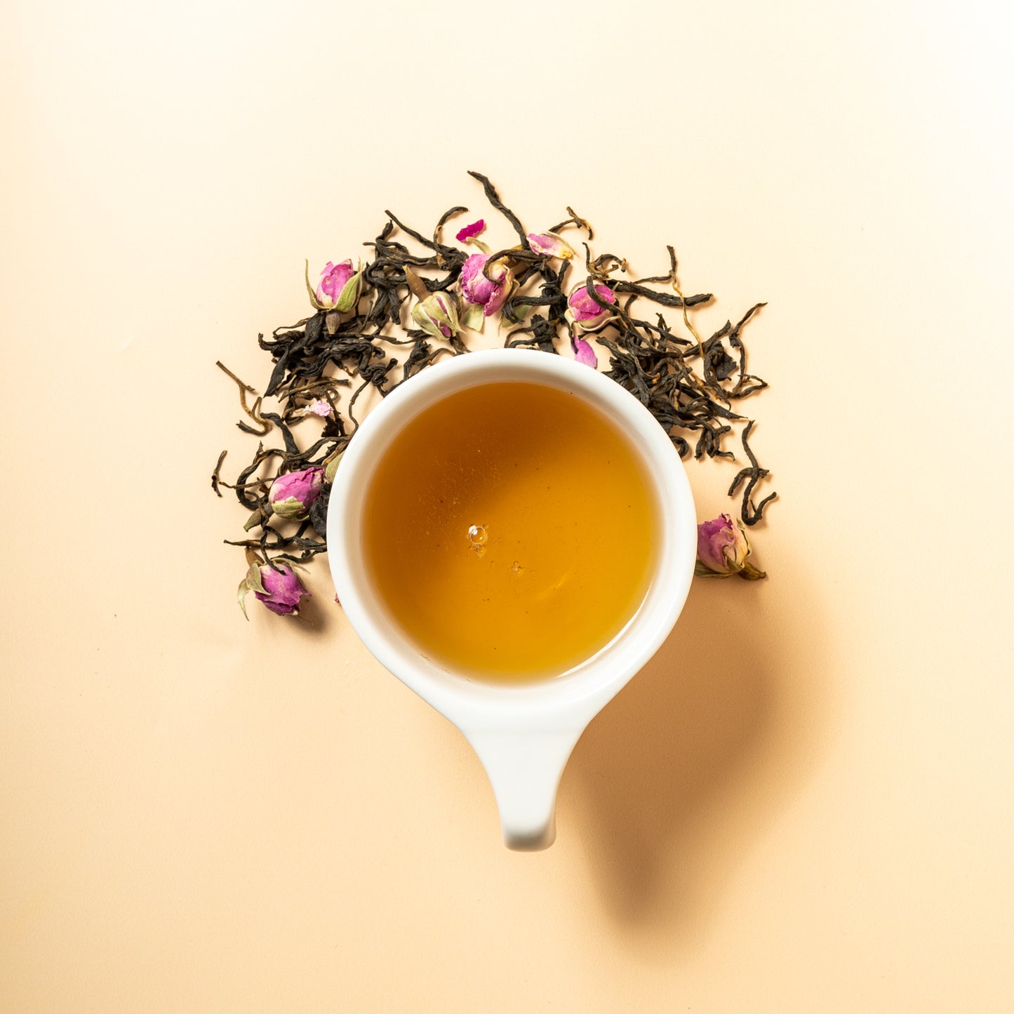A cup of kiss from a rose surrounded by the loose leaf blend of yunnan black tea with rose petals. 
