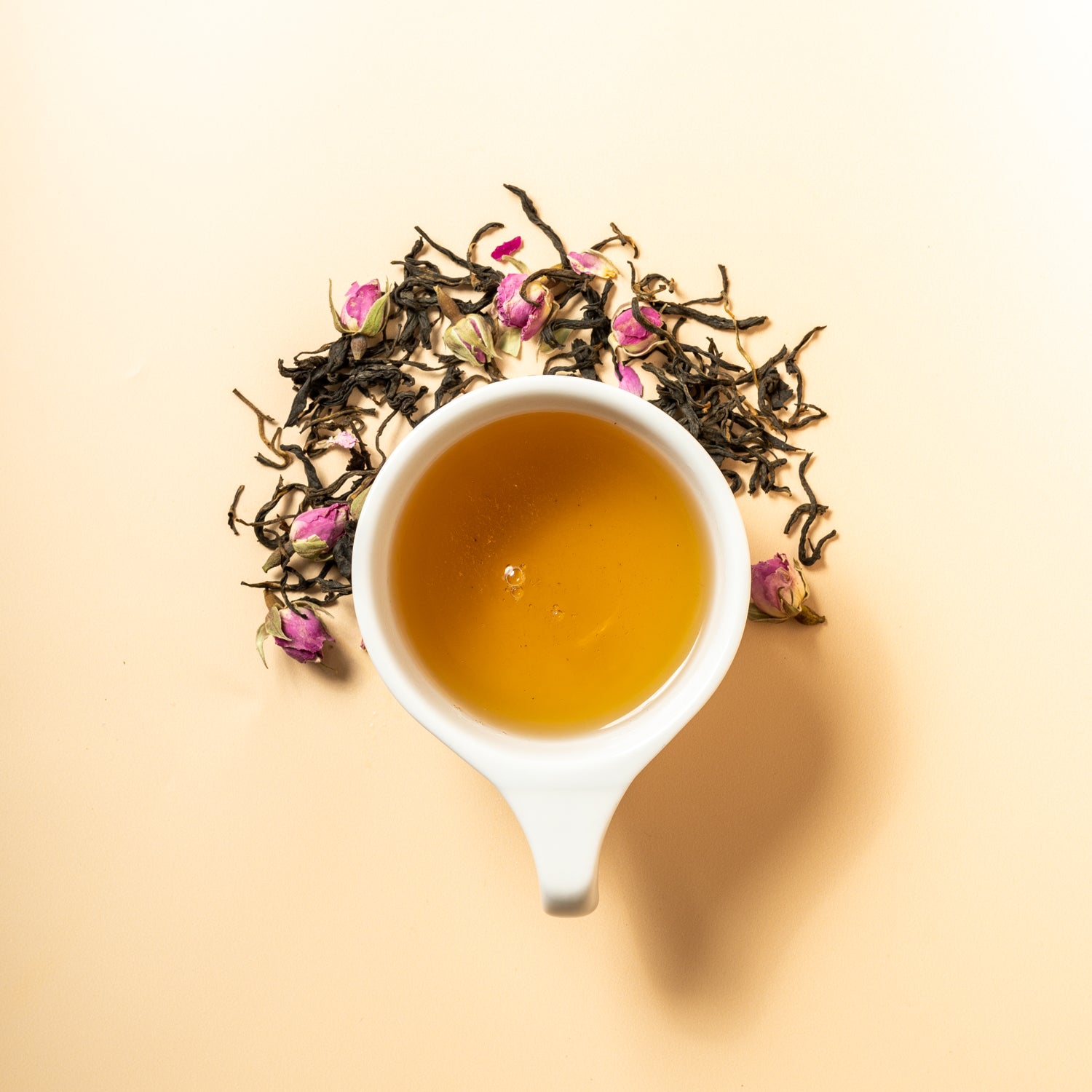 A cup of kiss from a rose surrounded by the loose leaf blend of yunnan black tea with rose petals. 