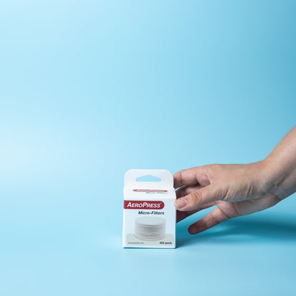 Hand picking up a 350-pack of AeroPress coffee filters