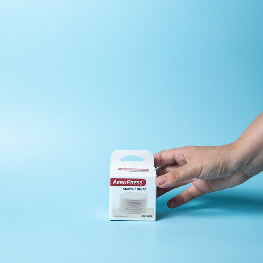 Hand picking up a 350-pack of AeroPress coffee filters